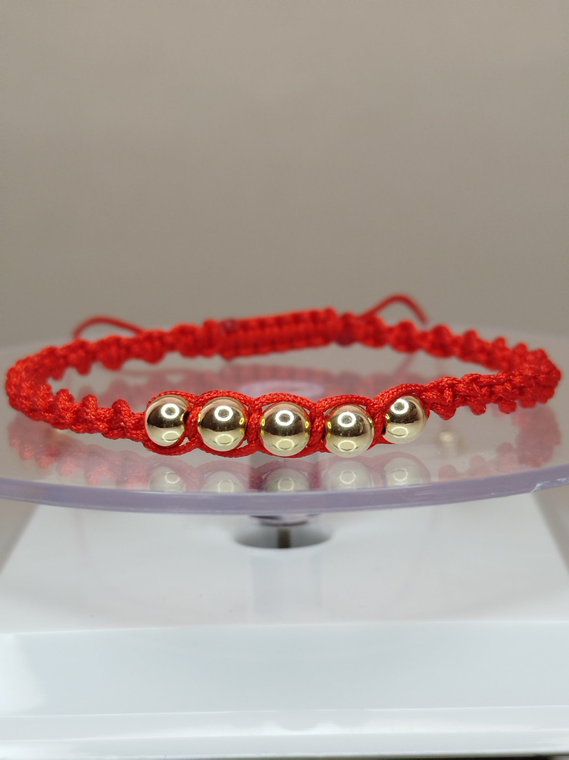 Pulsera de hilo rojo estilo turbillon con 7 pelotitas de oro 14k / oro 18k