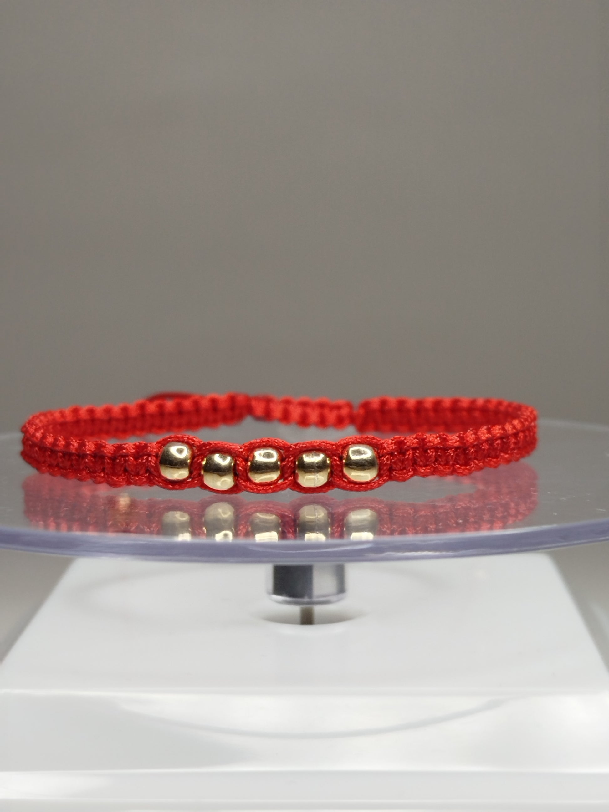 Pulsera de hilo rojo con 7 pelotitas de oro 18k